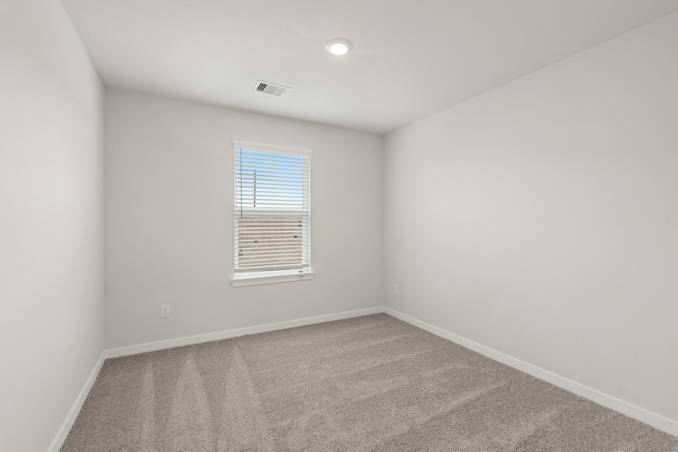 A room with a carpet and a window.