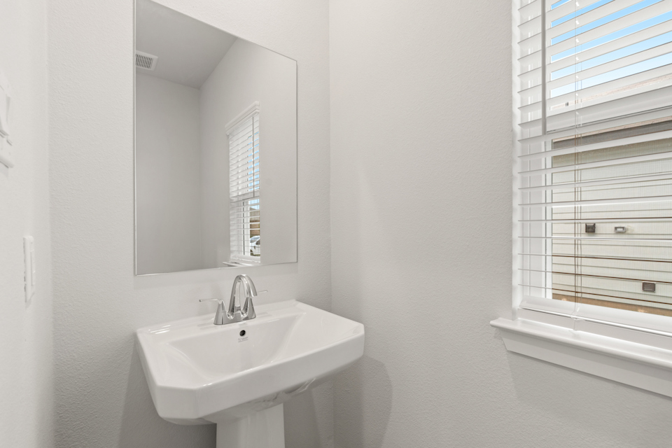 A bathroom with a sink and a mirror.