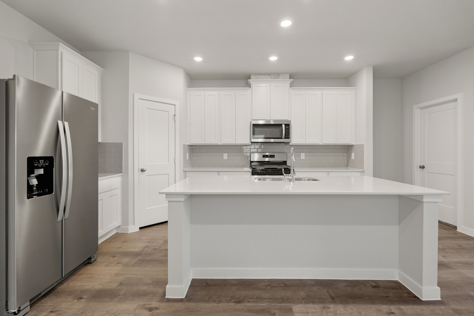 A kitchen with white cabinets.