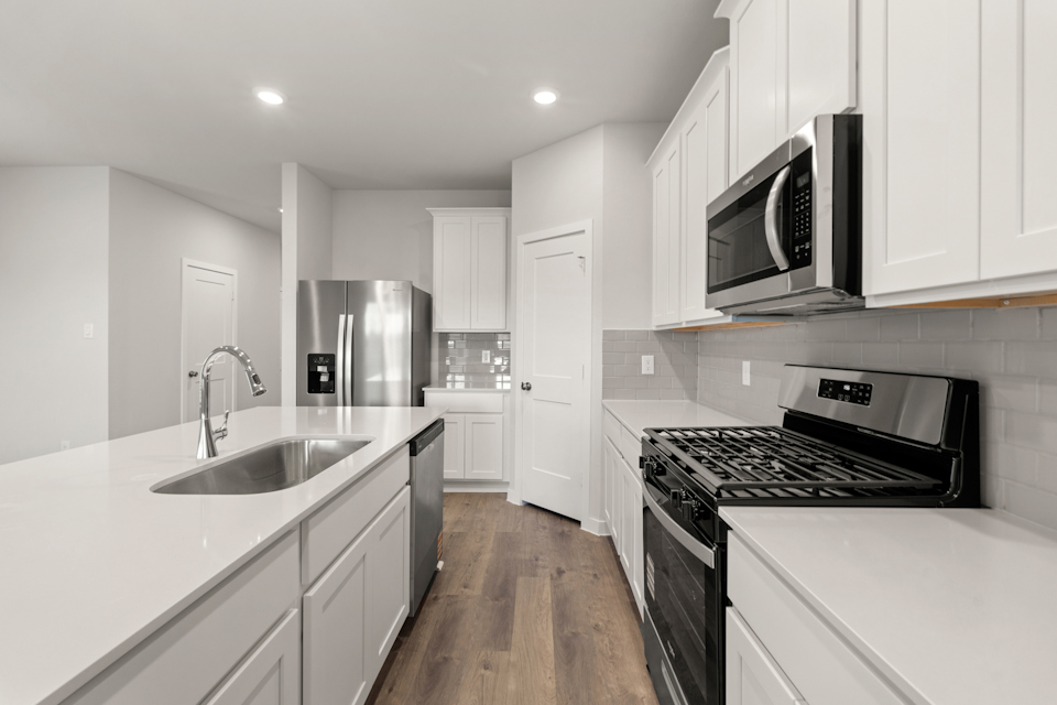 A kitchen with white cabinets.