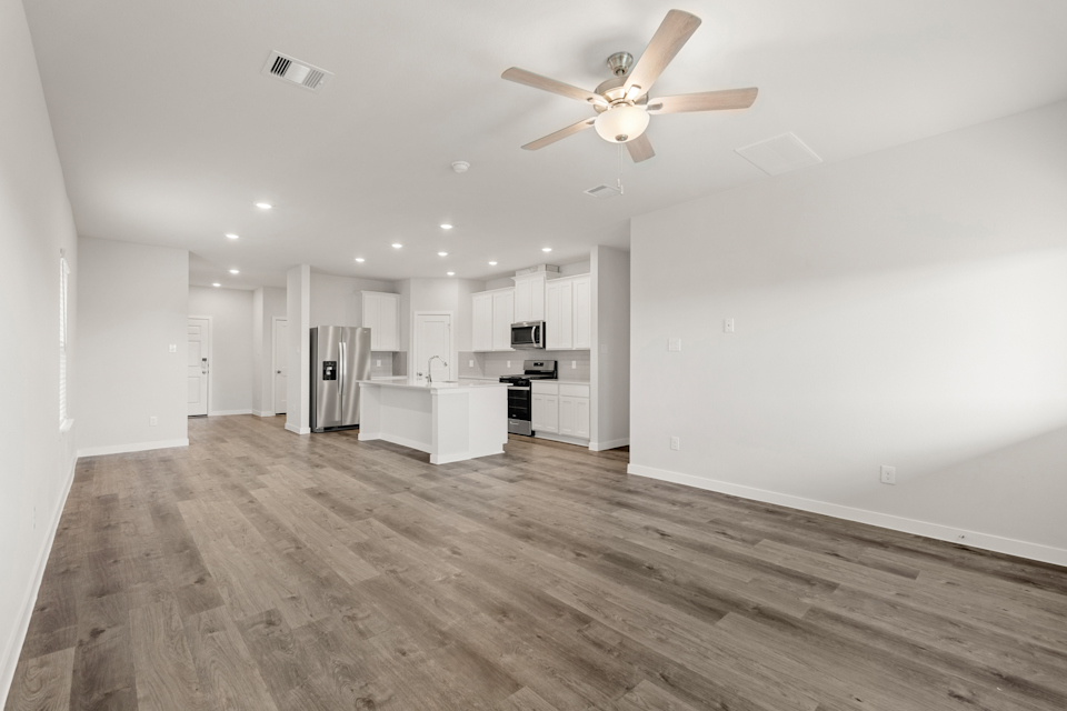 A large kitchen with a wood floor.