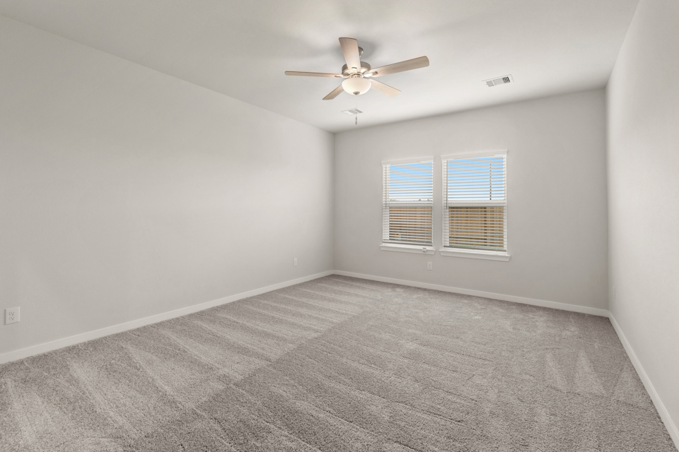A room with a ceiling fan and a window.