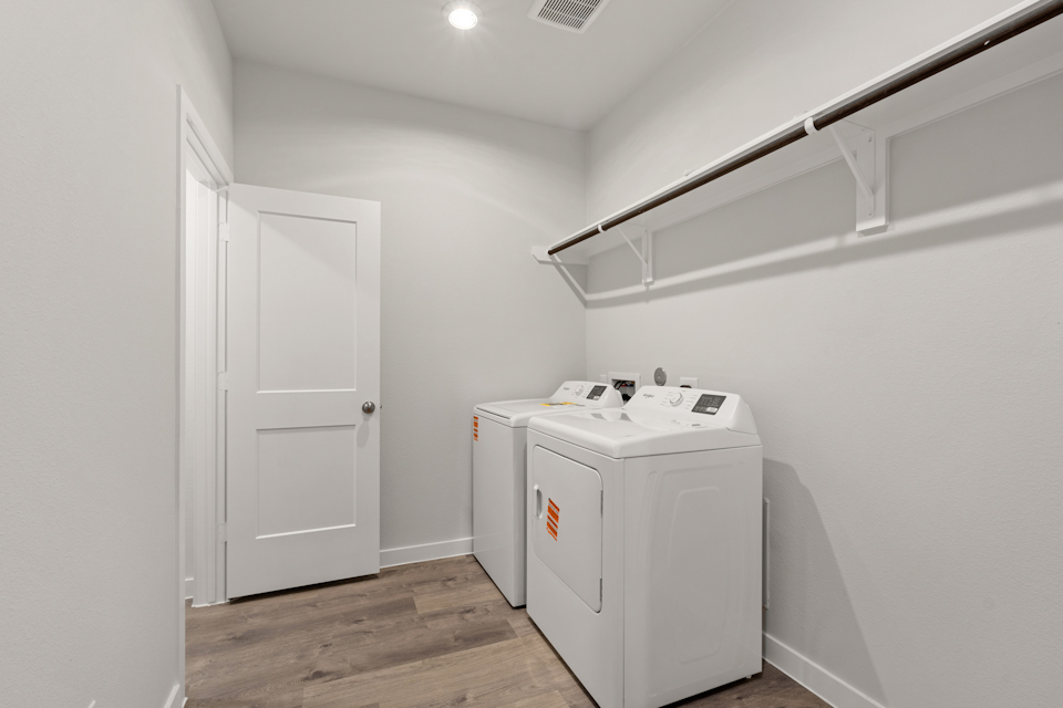 A white laundry room with a white door and a white door.