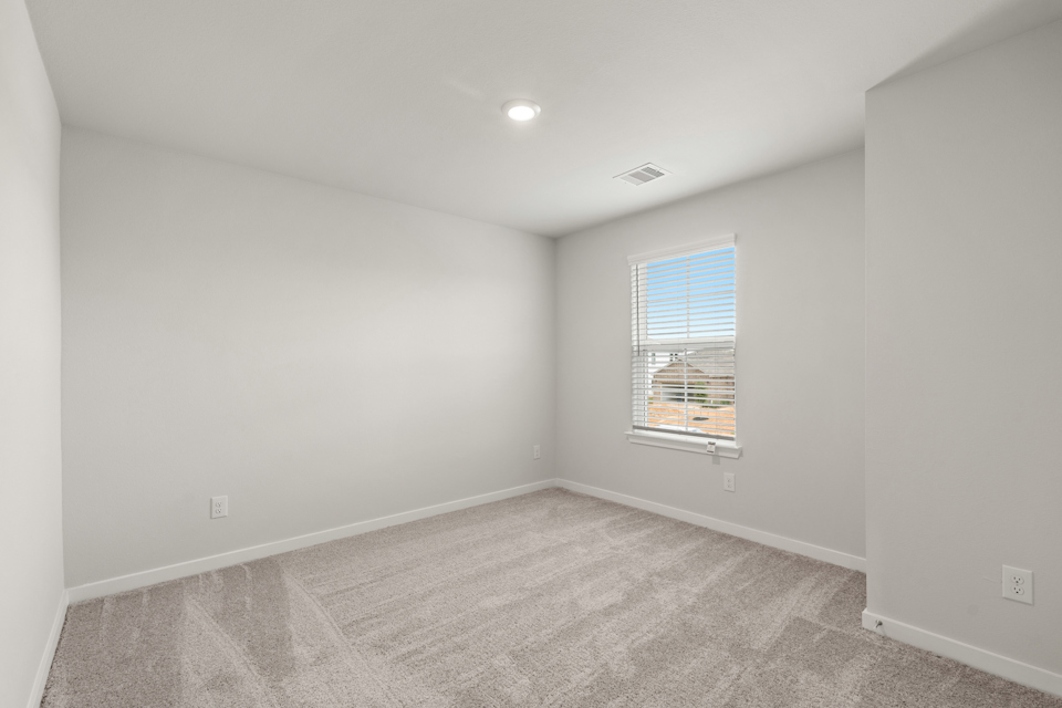 A room with a window and carpet.