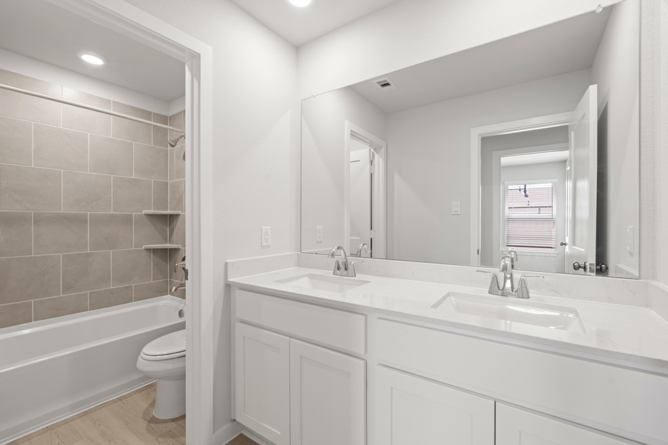 A bathroom with a tub sink and toilet.