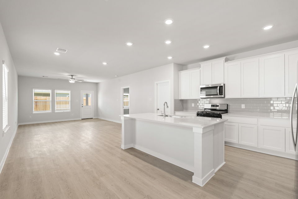A kitchen with white cabinets.