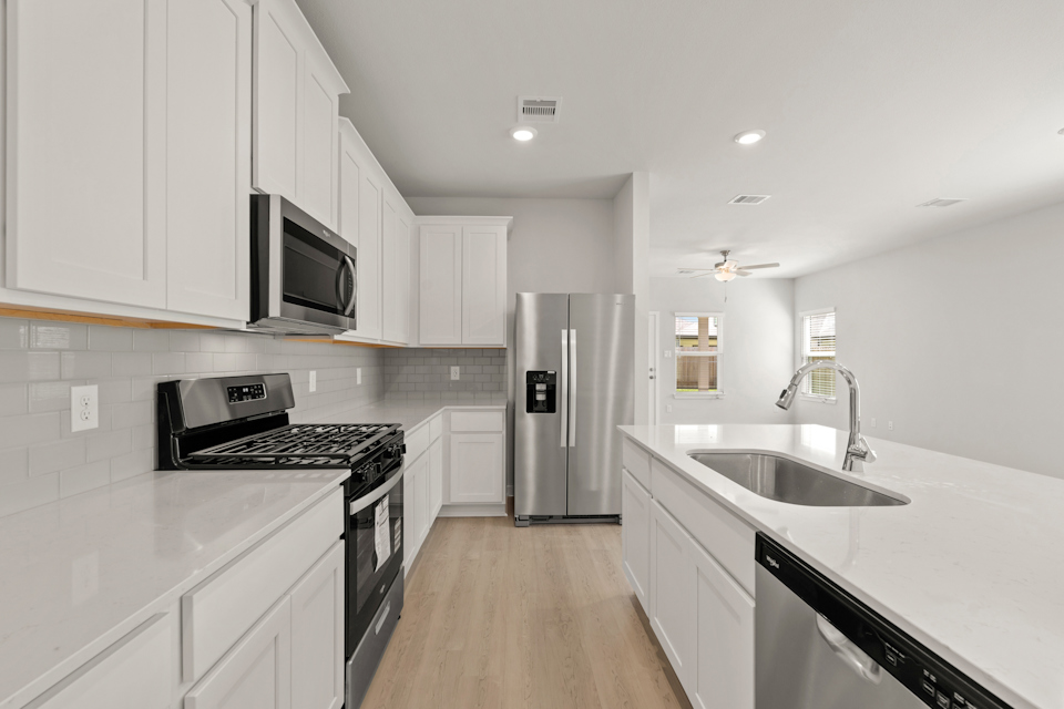 A kitchen with white cabinets.