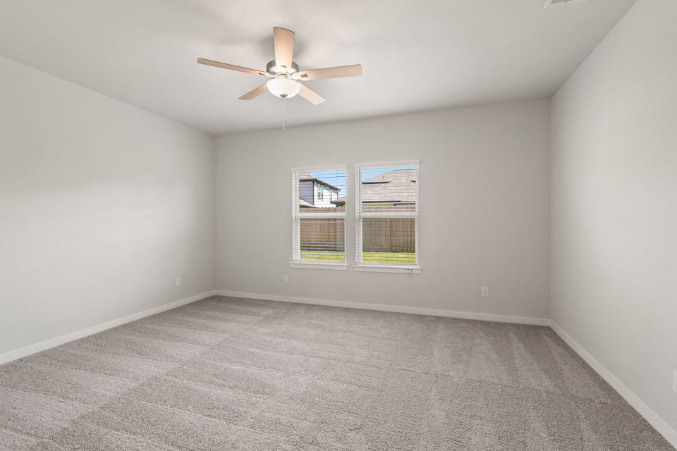 A room with a ceiling fan and a window.