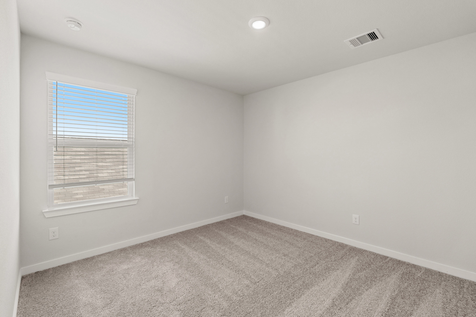 A room with a window and a carpet.