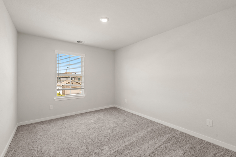 A room with a window and a carpet.