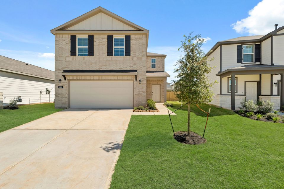 A house with a tree in the front yard.
