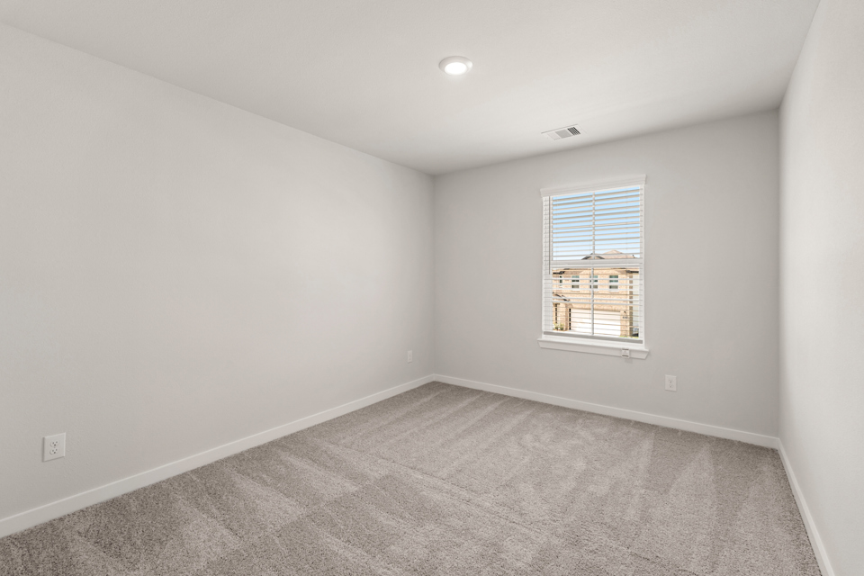 A room with a window and a carpet.