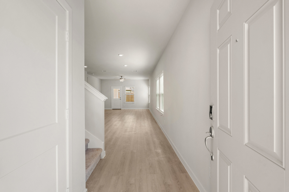 A long hallway with white doors.