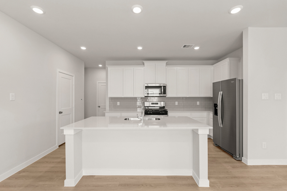 A kitchen with white cabinets.