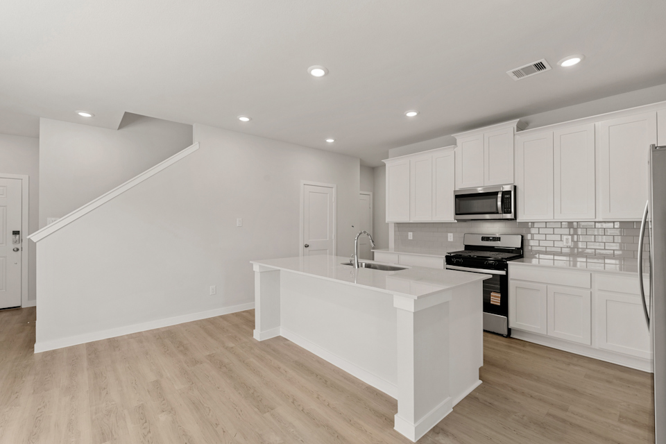A kitchen with white cabinets.