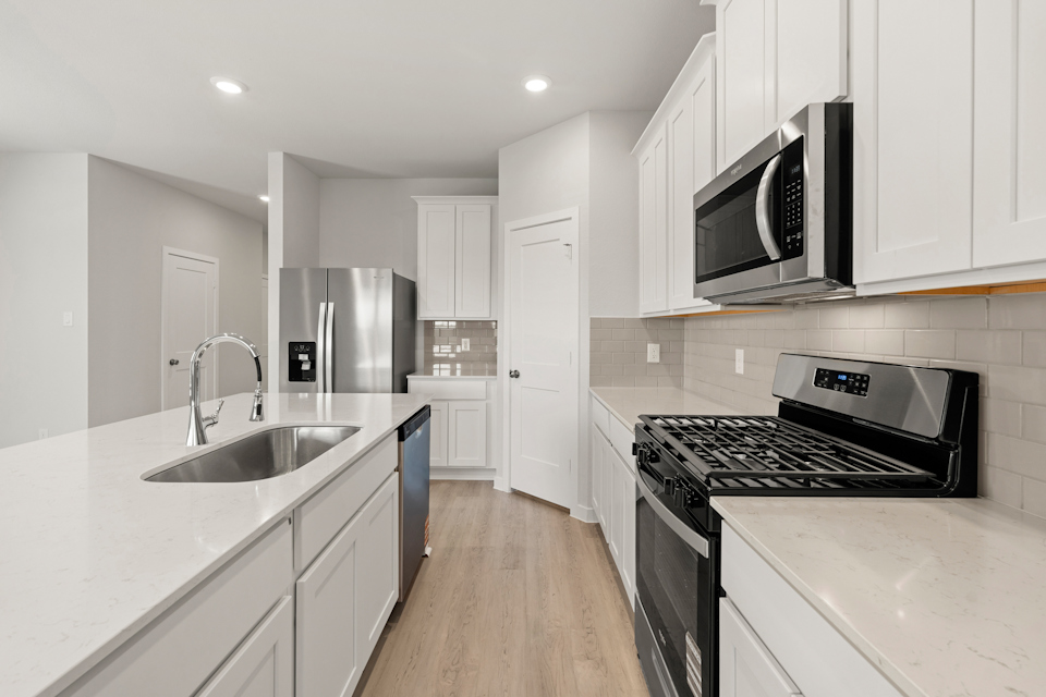 A kitchen with white cabinets.