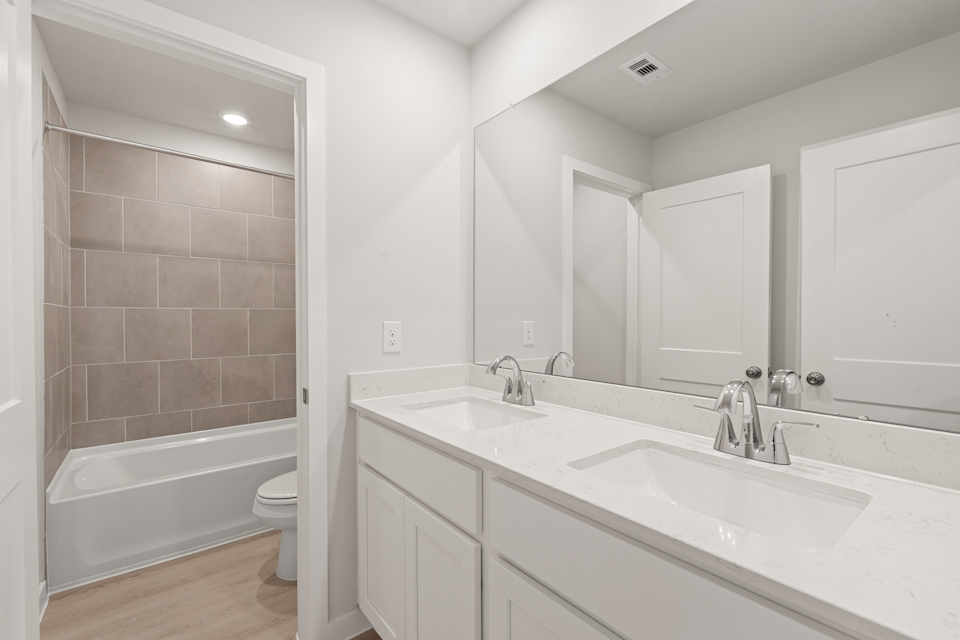 A bathroom with a tub sink and toilet.
