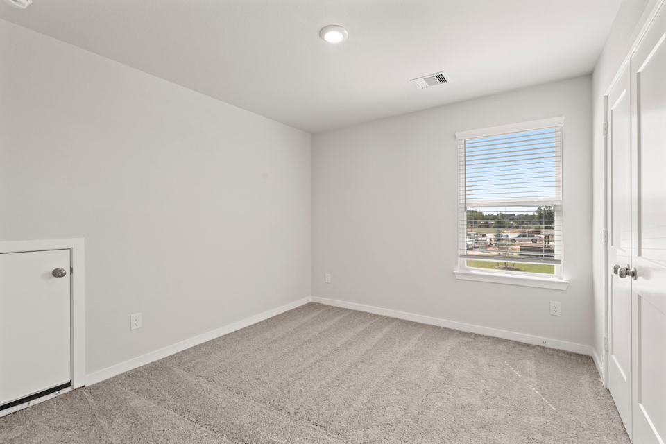 A room with a window and a carpet.