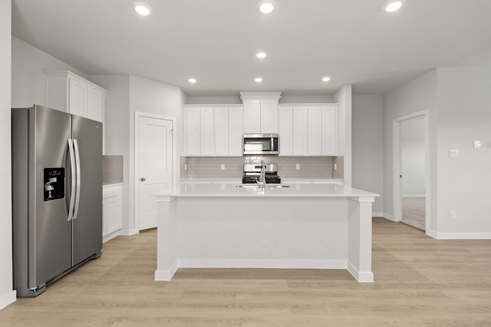 A kitchen with white cabinets.