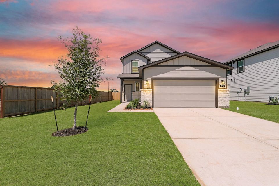 A house with a tree in the front yard.