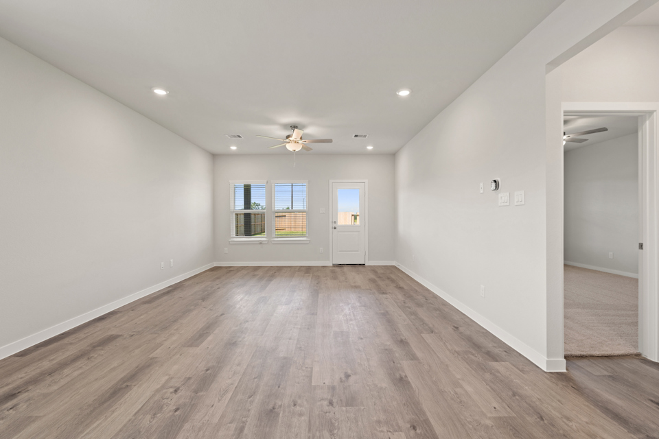 A room with a wood floor and a ceiling fan.