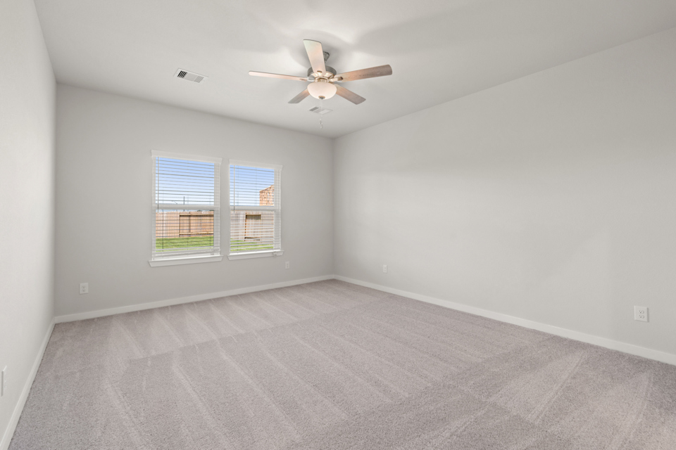 A room with a ceiling fan and a window.