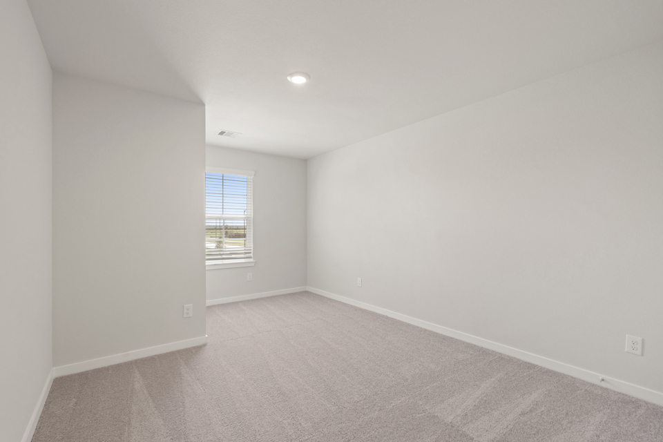 A room with a carpet and a window.
