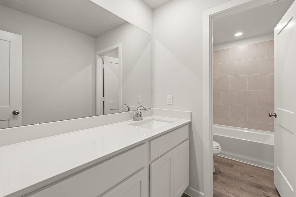 A bathroom with a tub sink and toilet.
