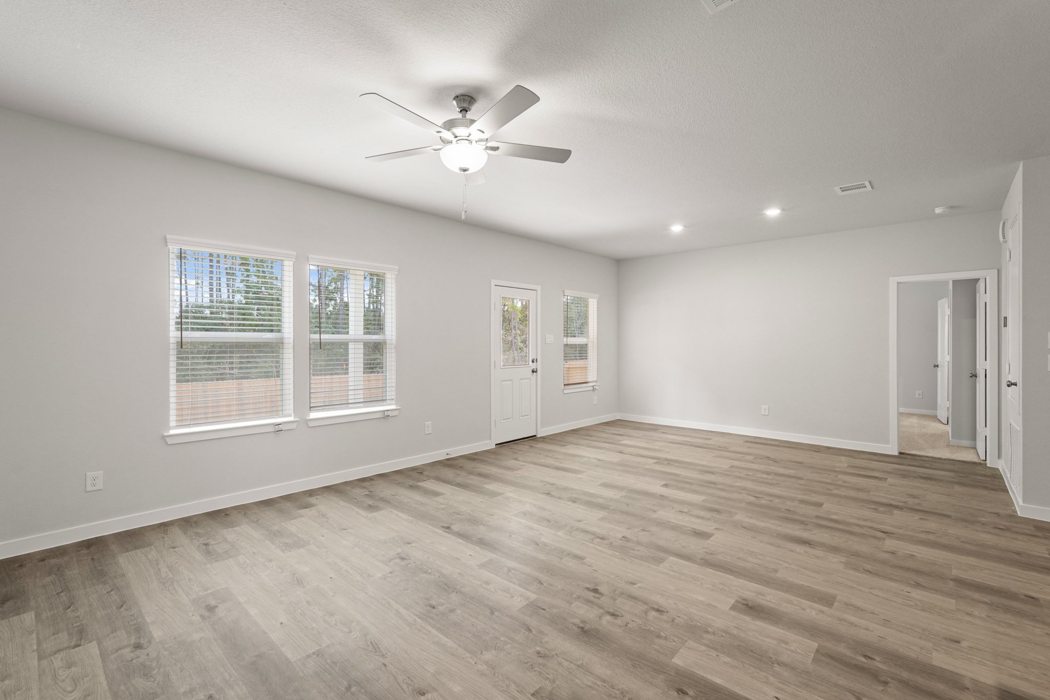 A room with a wood floor and a ceiling fan.