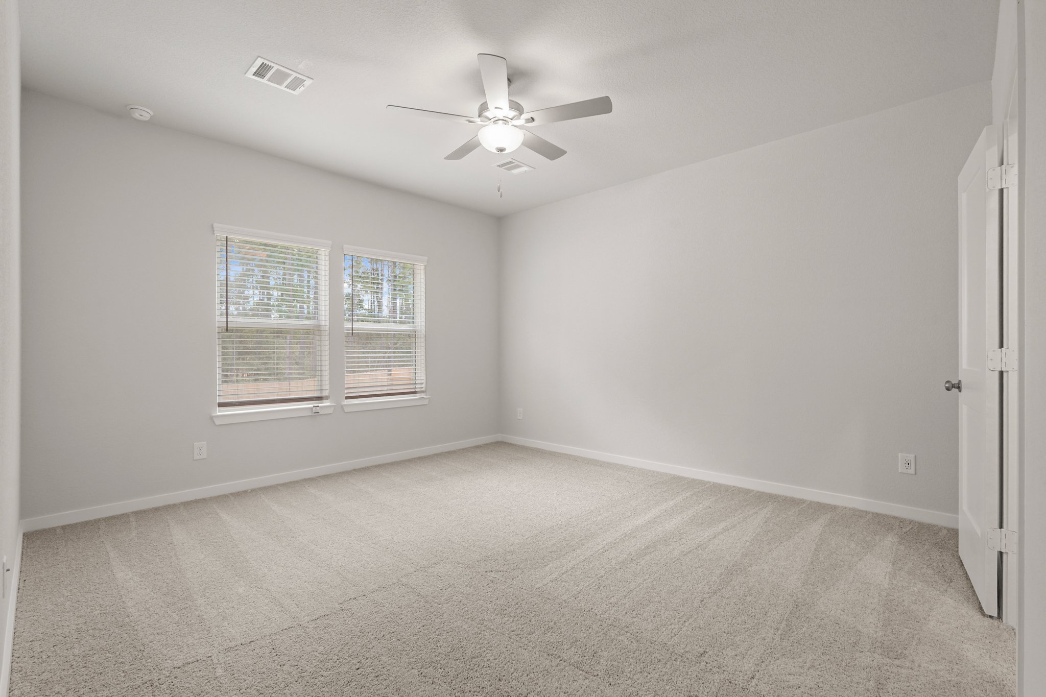 A room with a ceiling fan and a window.