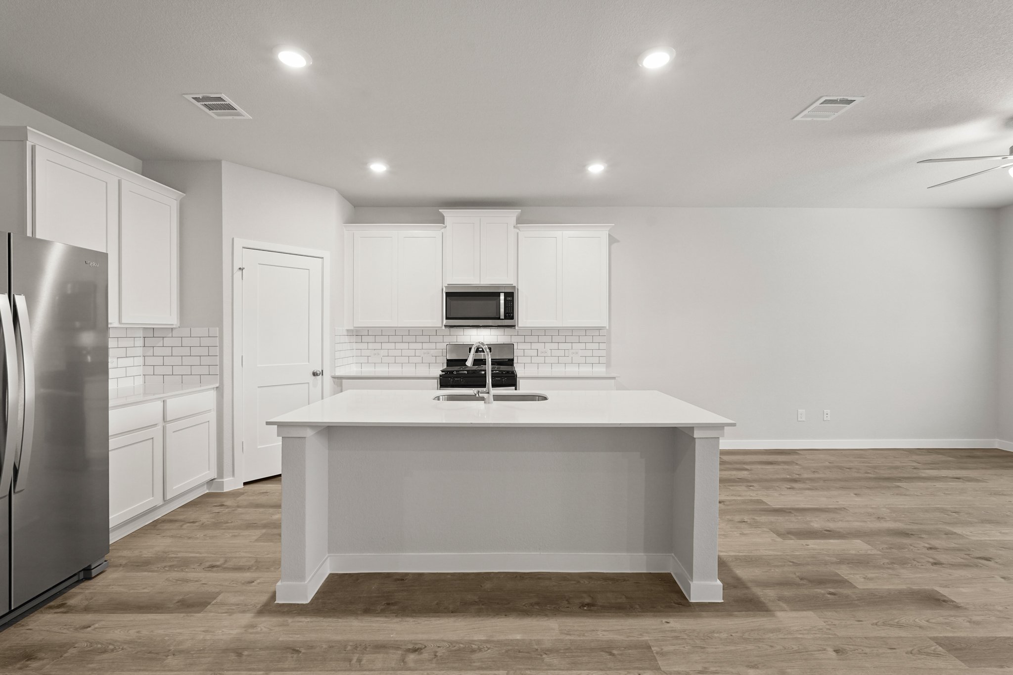 A kitchen with white cabinets.