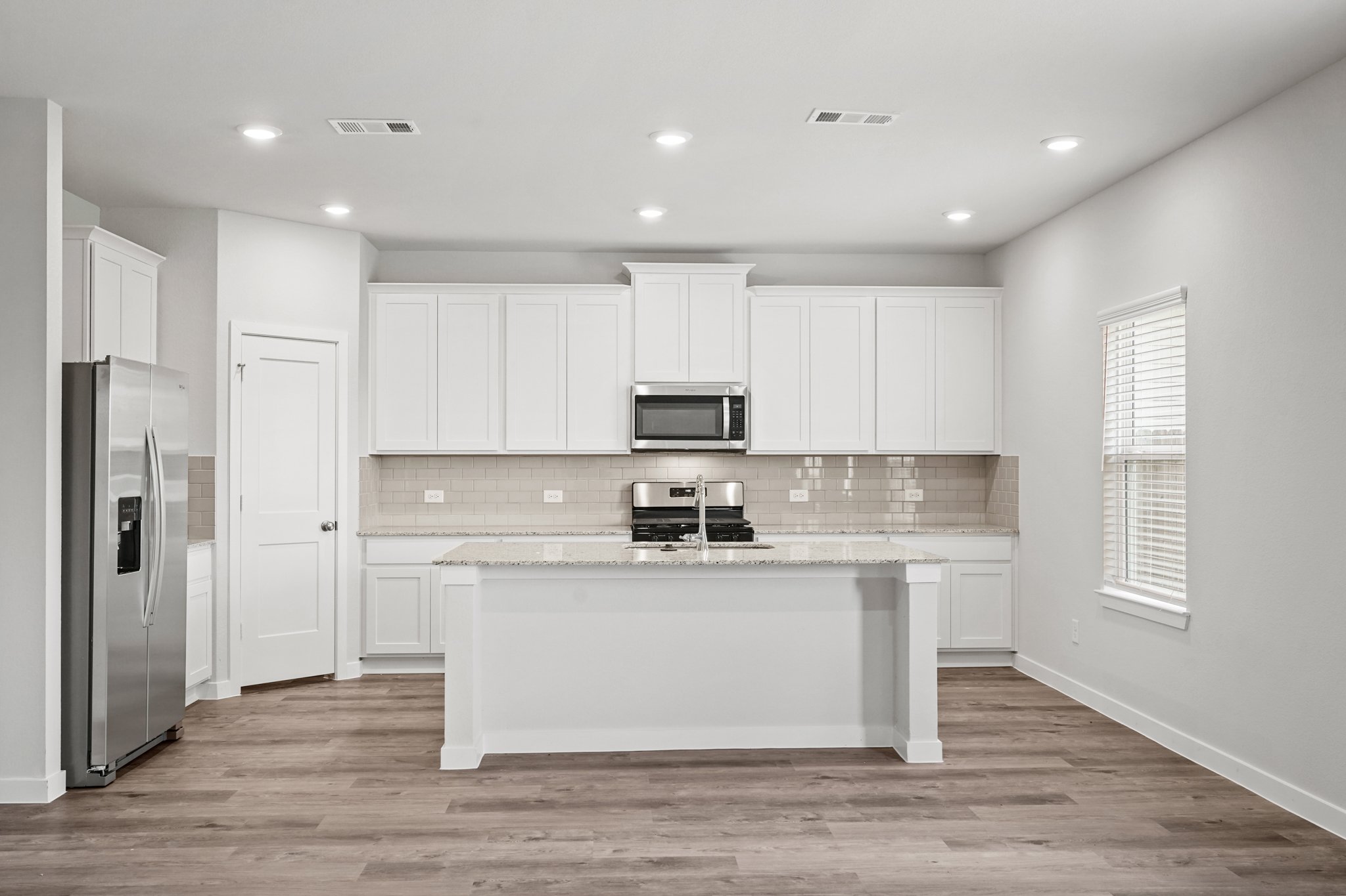 A kitchen with white cabinets.