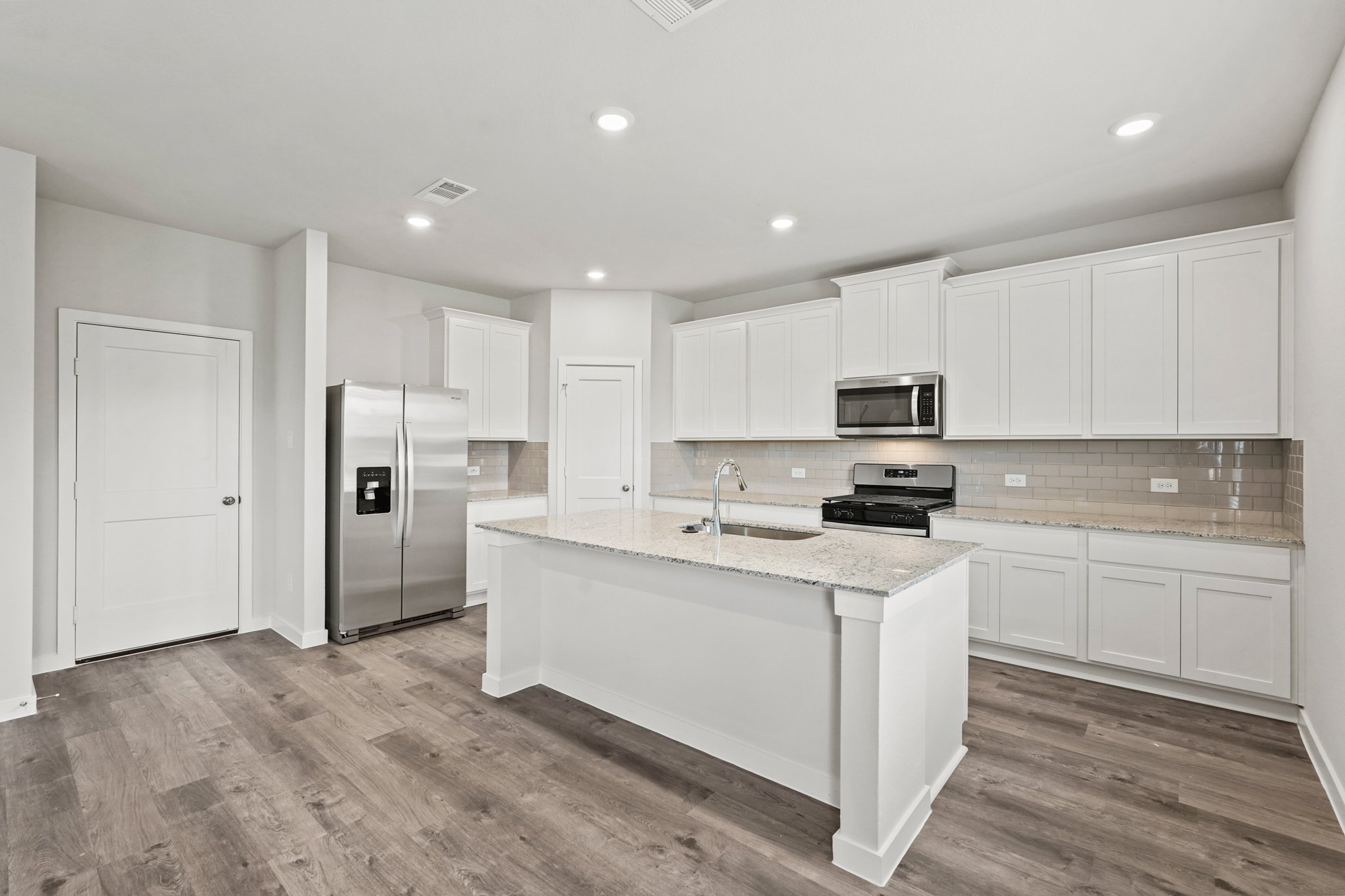 A kitchen with white cabinets.