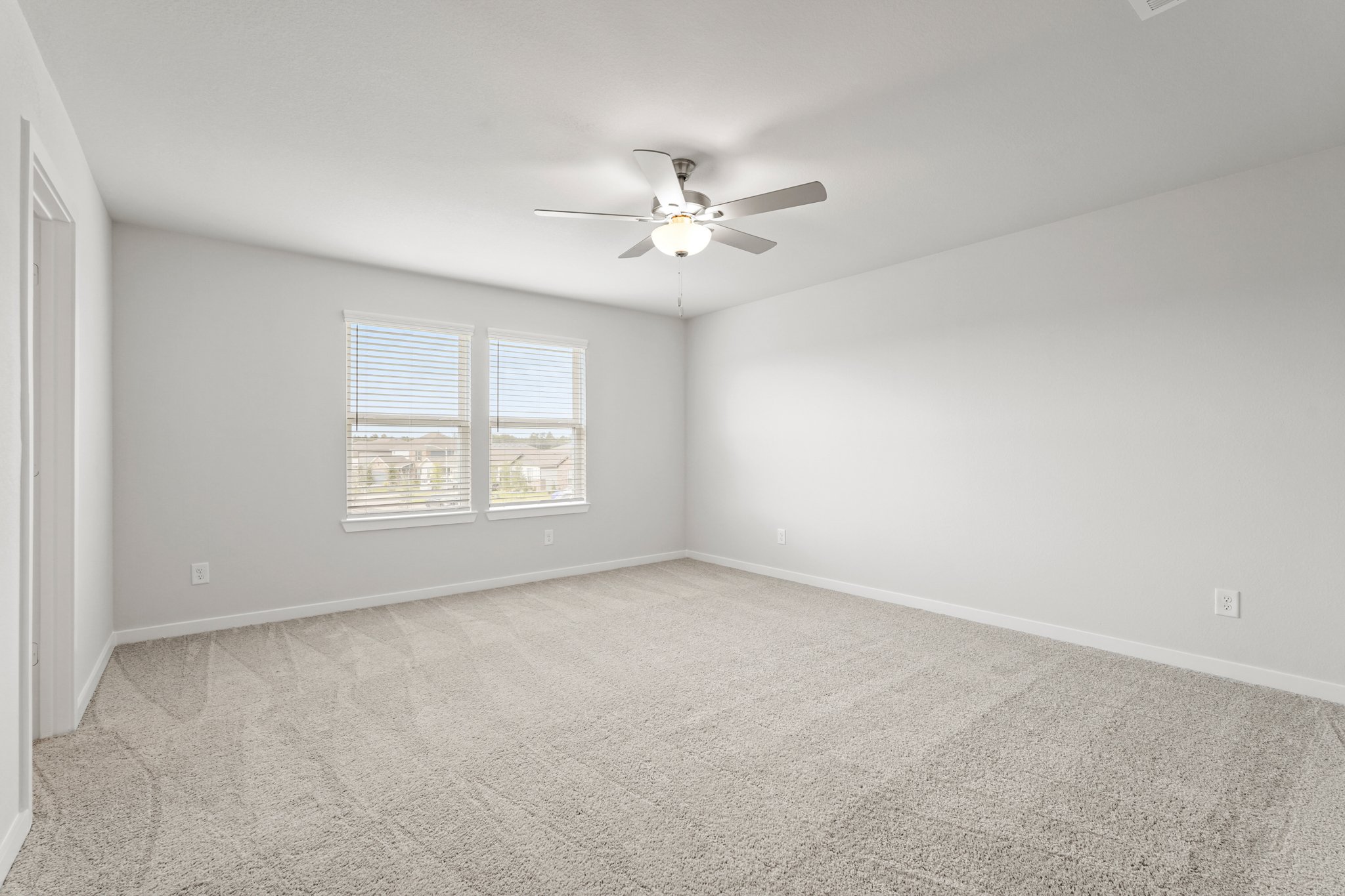 A room with a ceiling fan and a window.