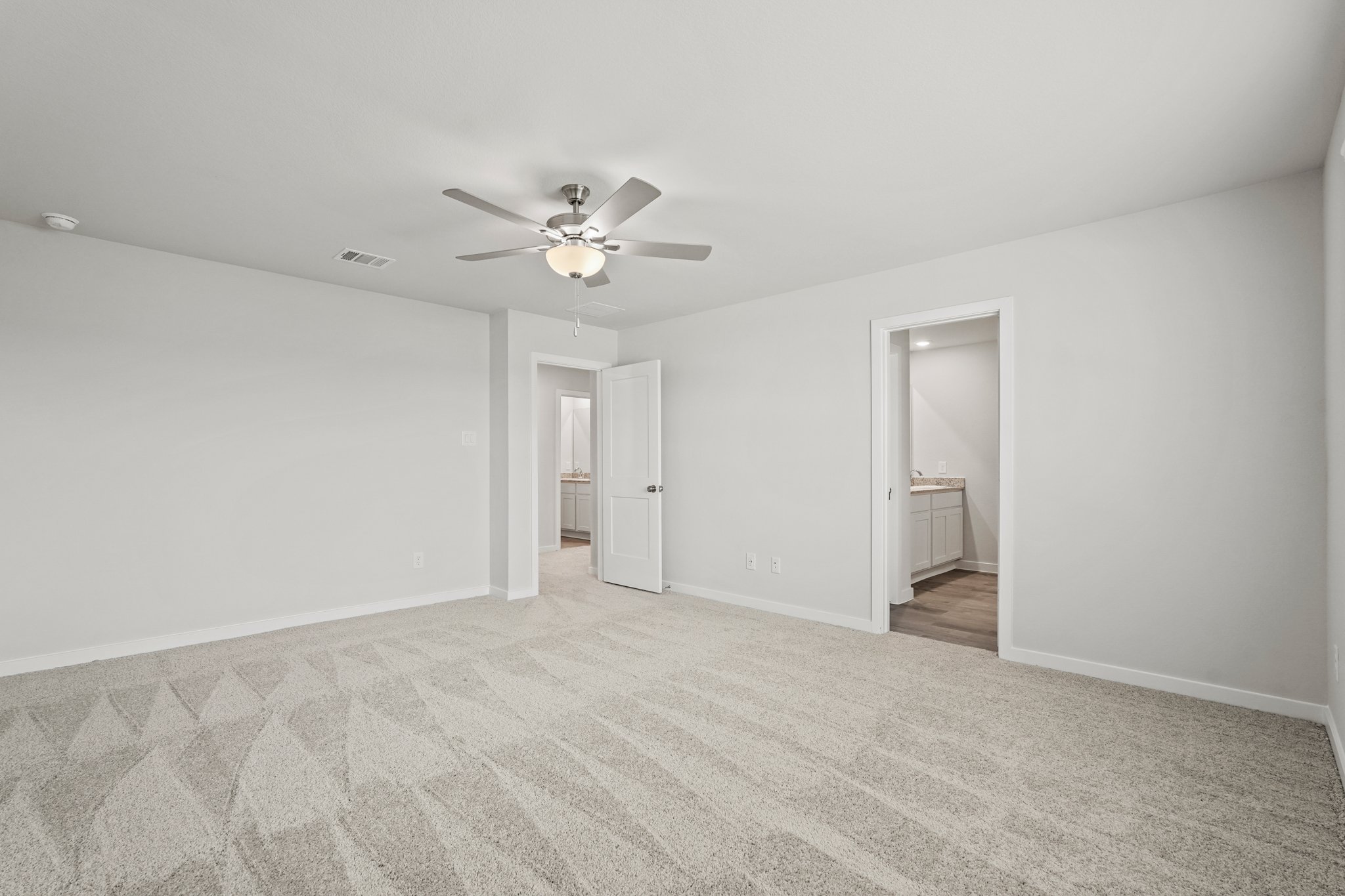 A room with a ceiling fan and a door.
