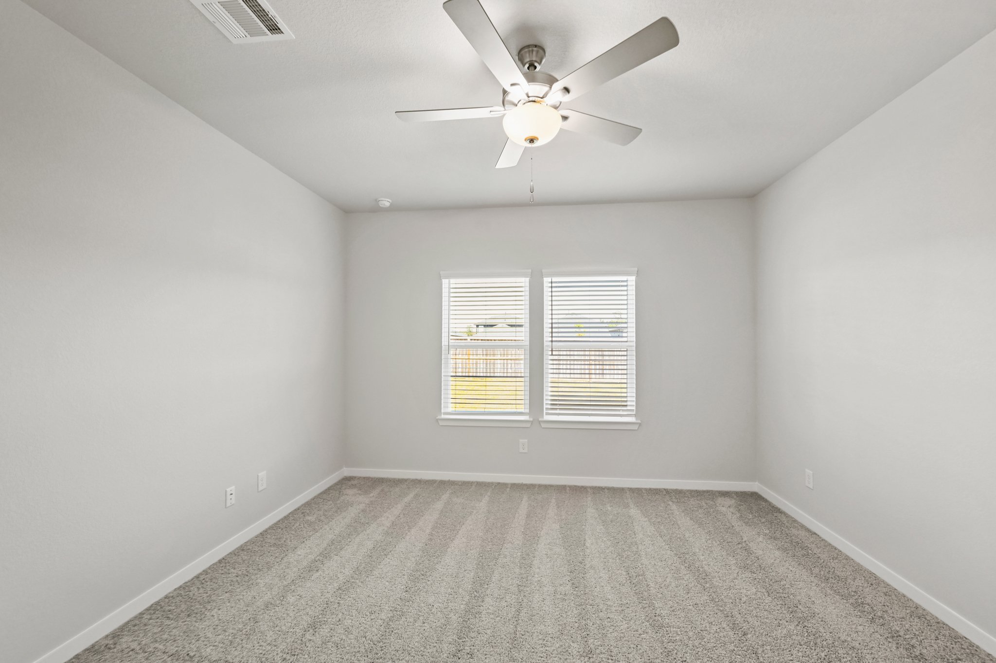 A room with a ceiling fan and a window.