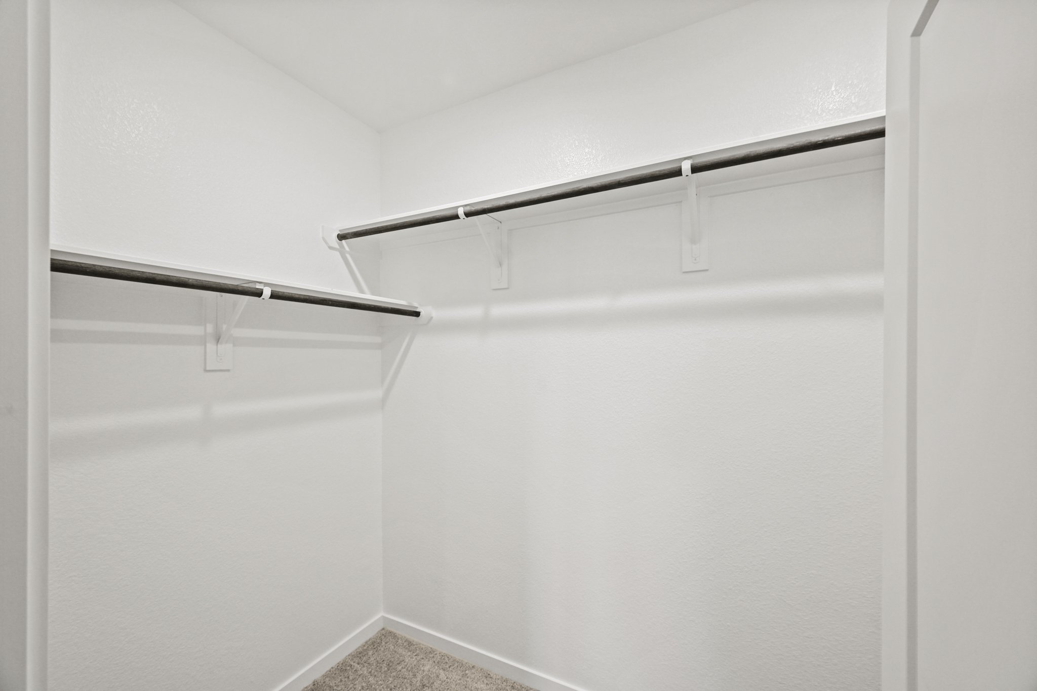 A white wall with a metal bar.