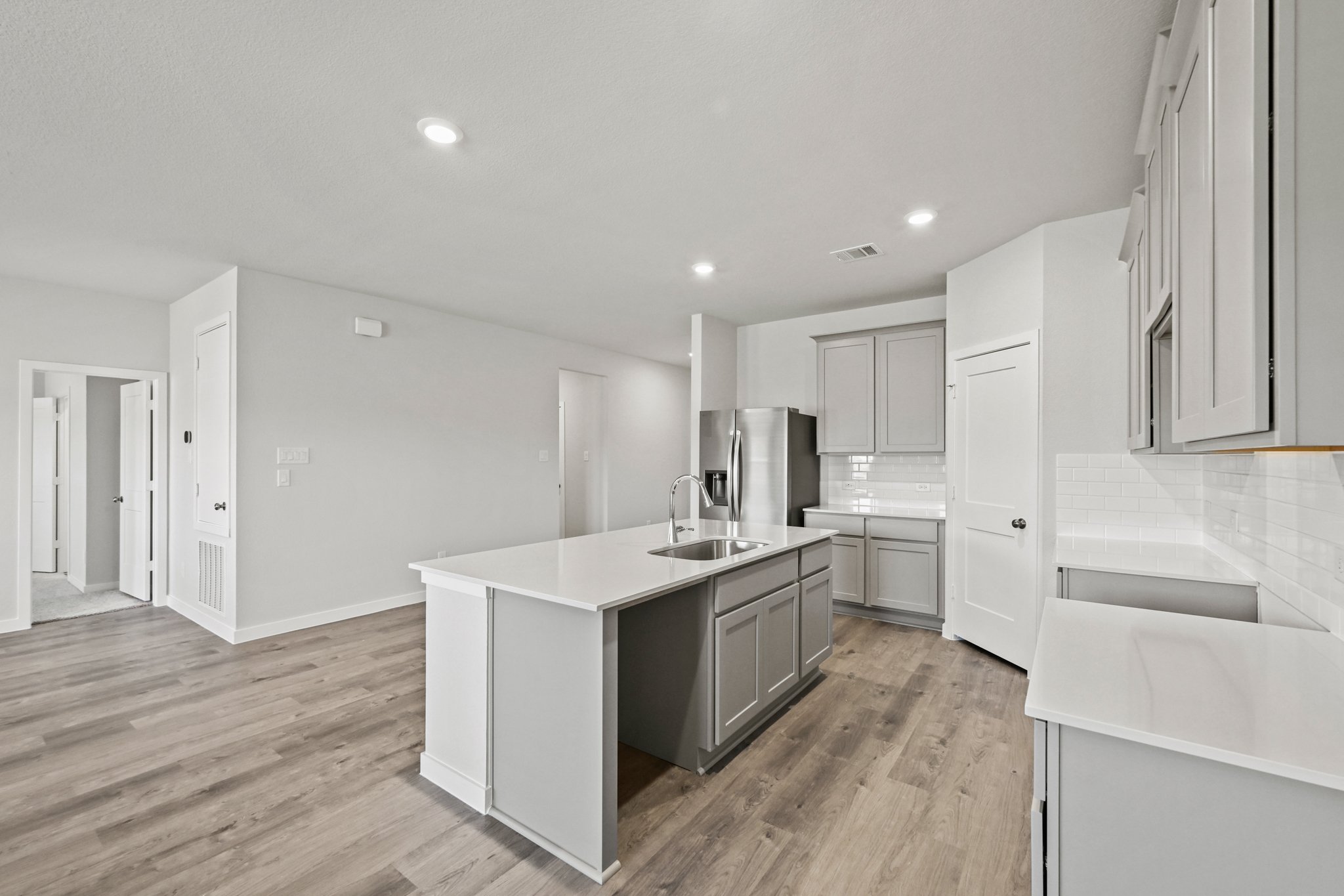 A kitchen with white cabinets.