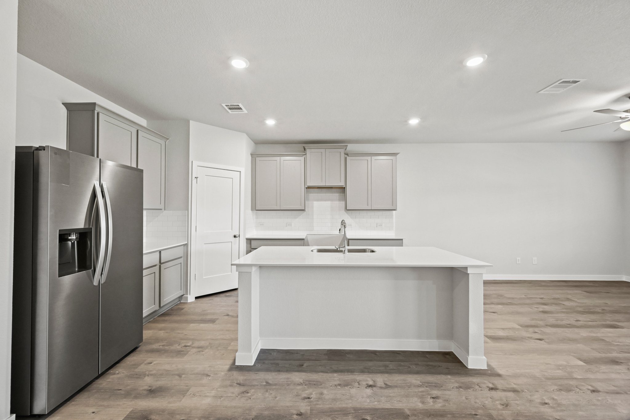 A kitchen with white cabinets.