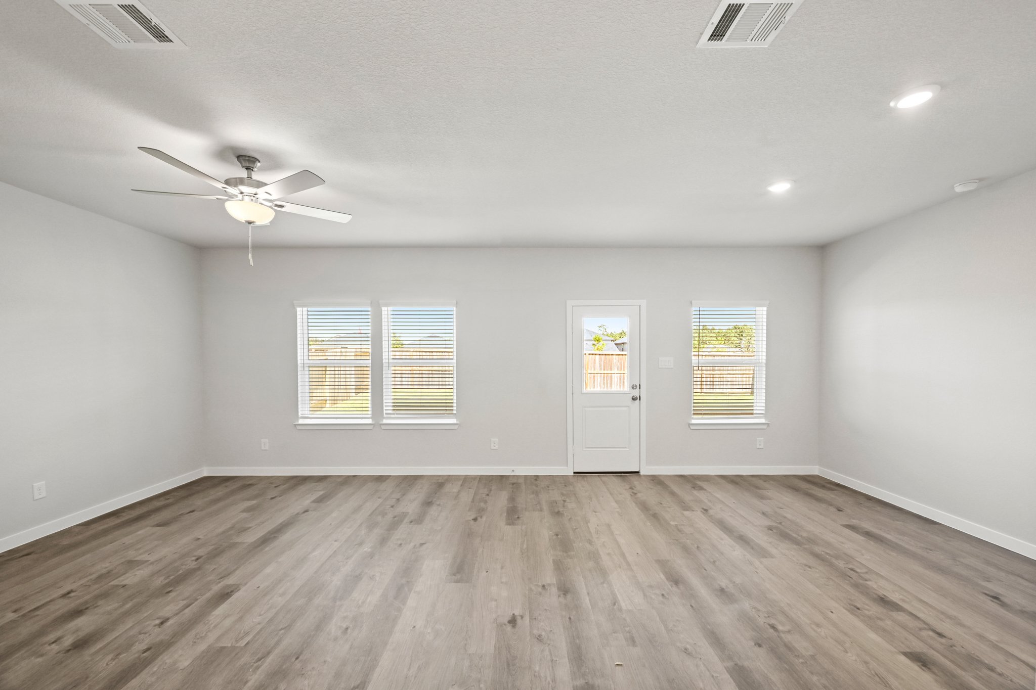 A room with a wood floor and a ceiling fan.