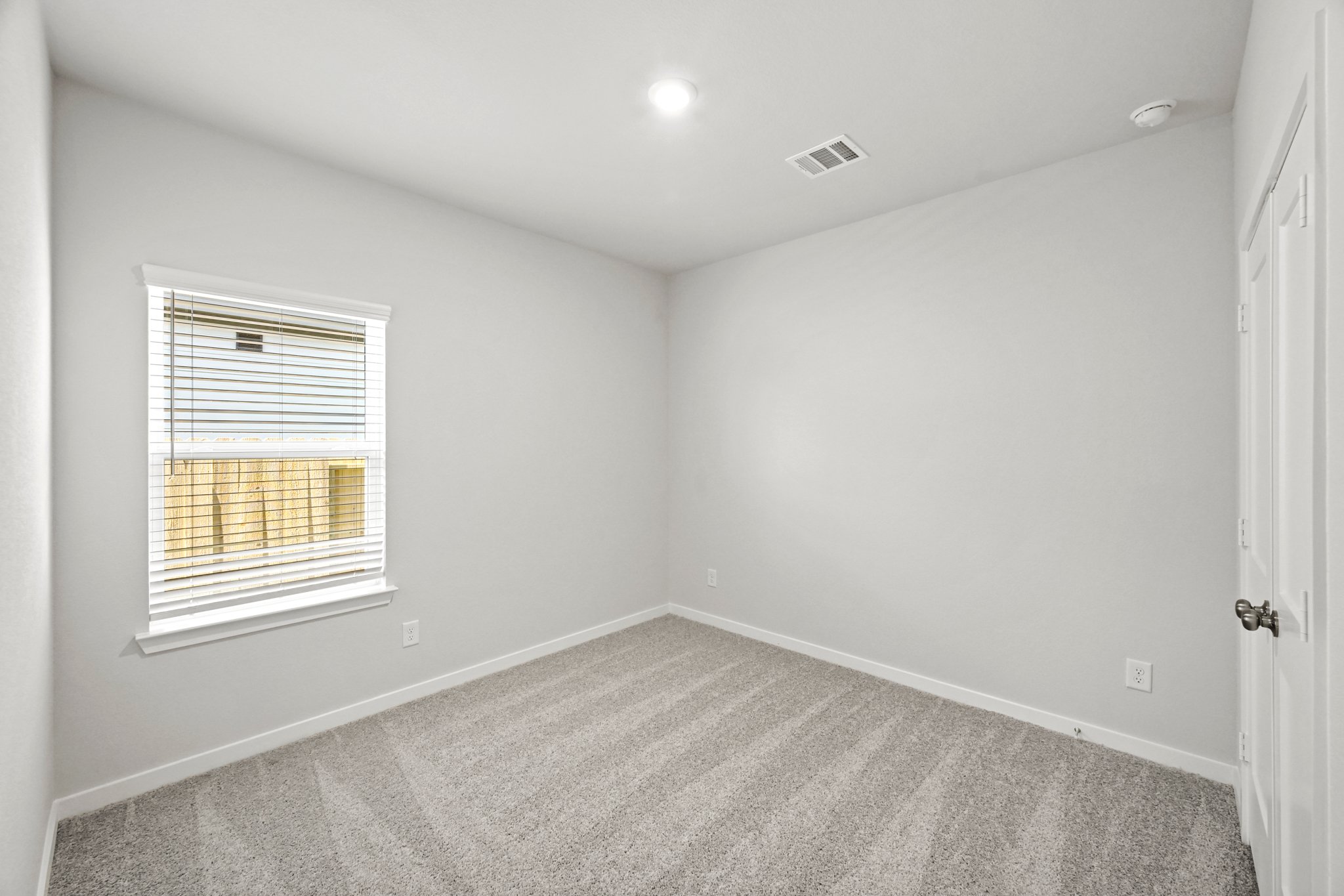 A room with a carpet and a window.
