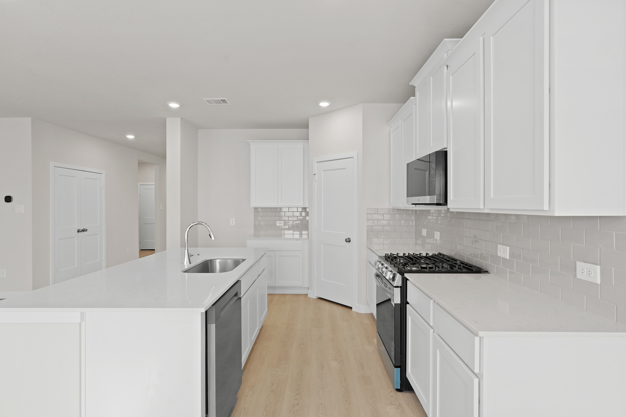 A kitchen with white cabinets.
