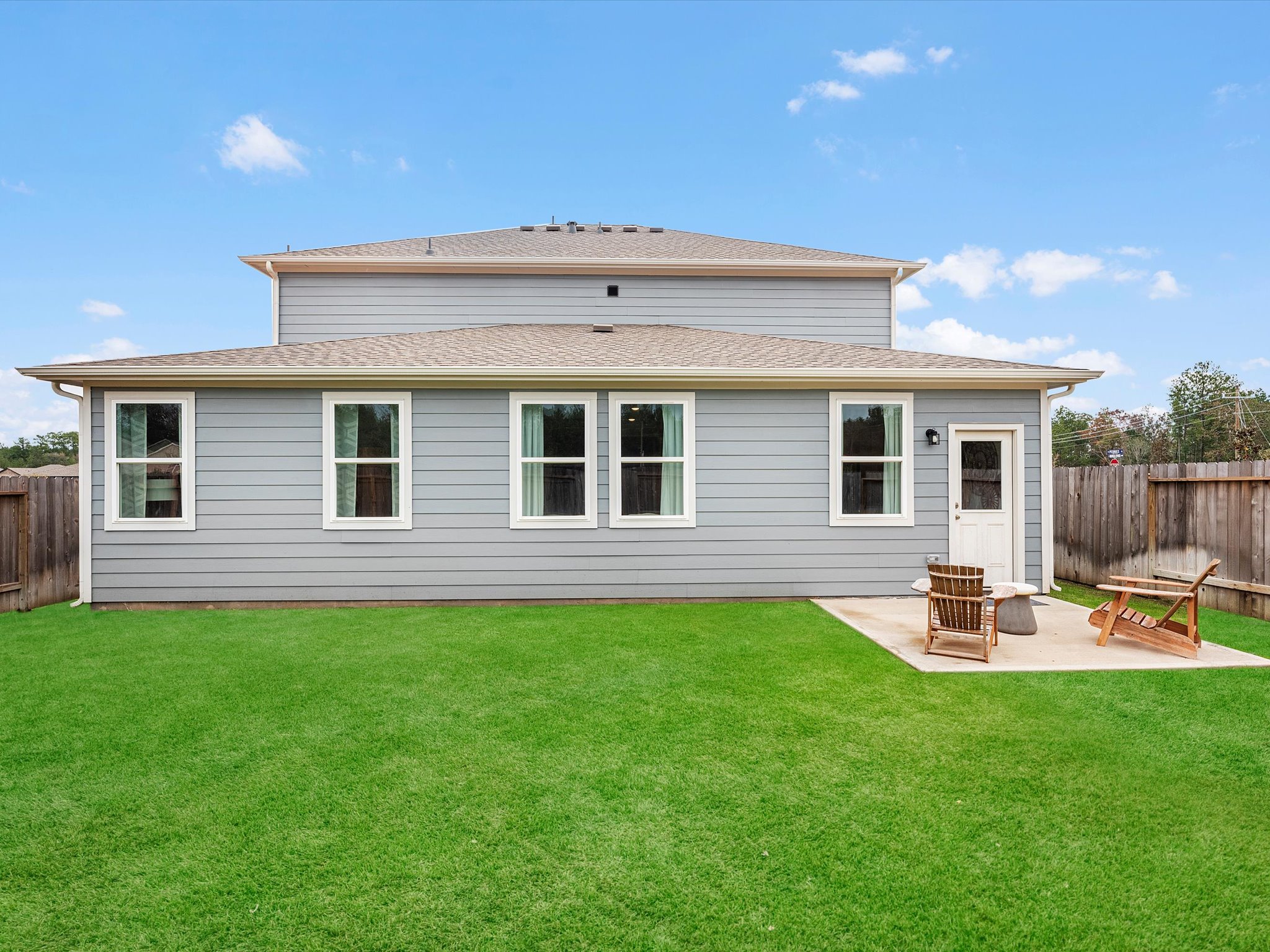A house with a lawn and chairs.