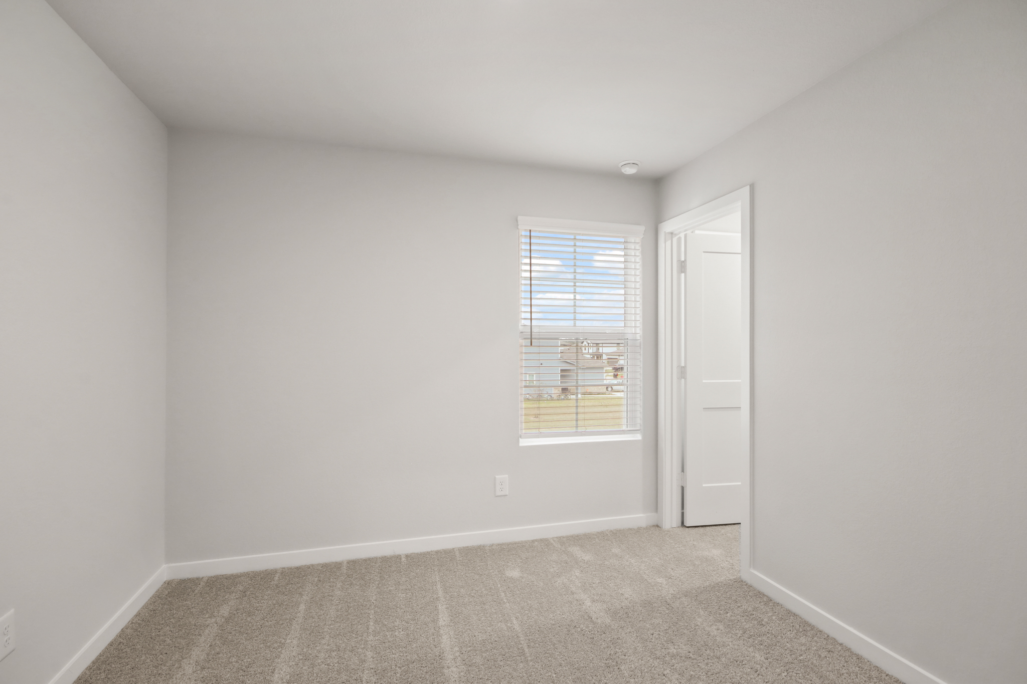 A room with a window and a carpet.