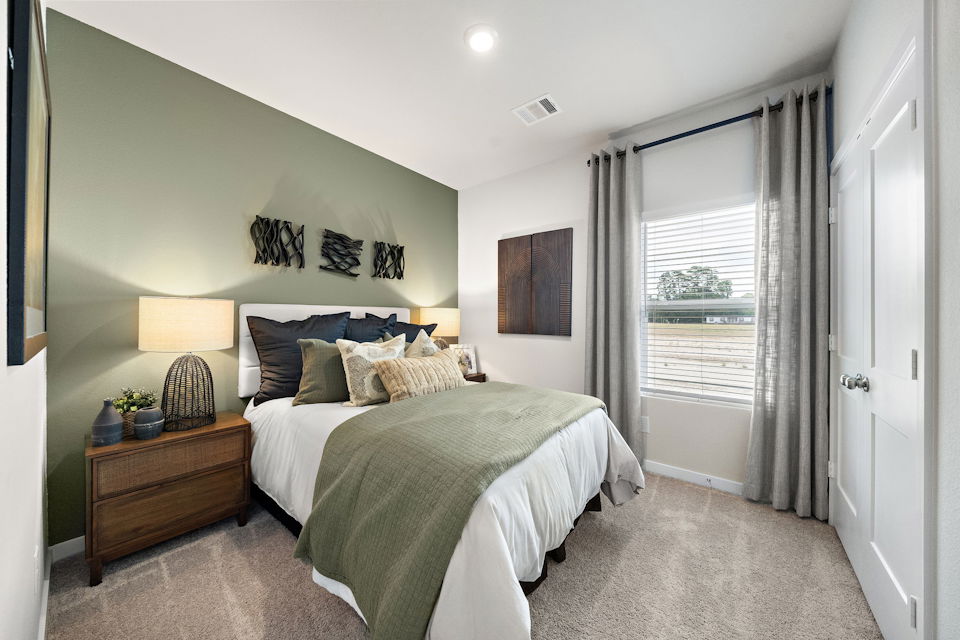 A bedroom with a large window.