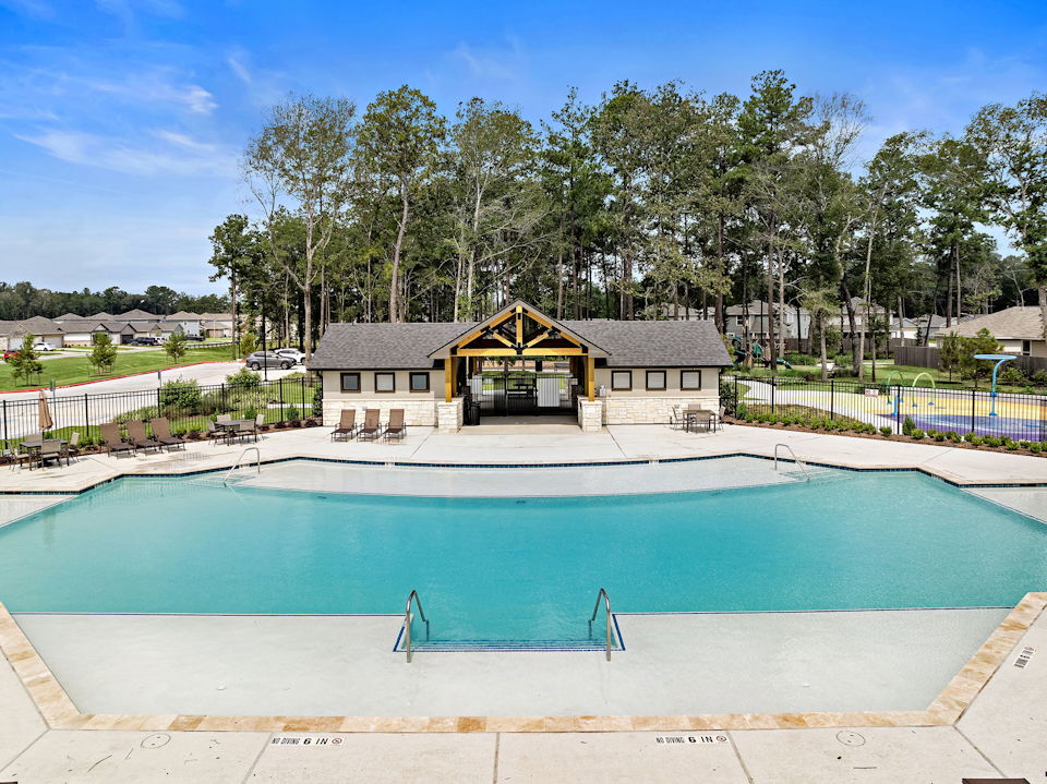 A swimming pool with a house in the background.
