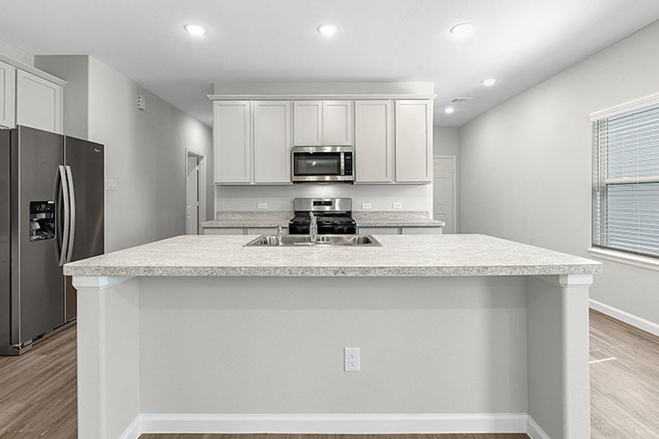 A kitchen with white cabinets.