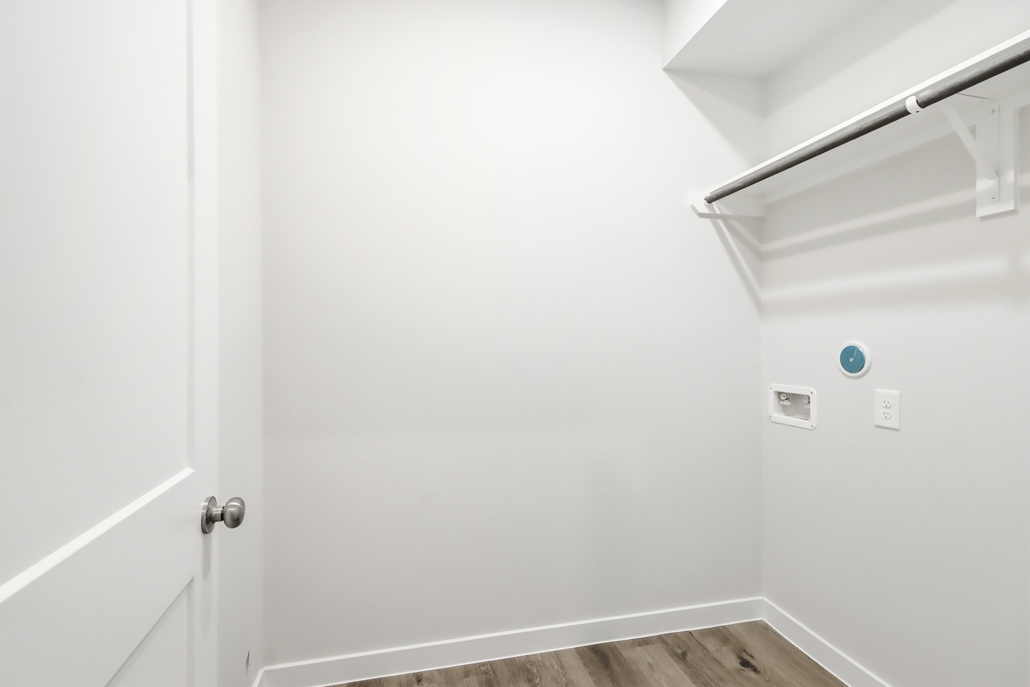 A white wall with a metal bar.