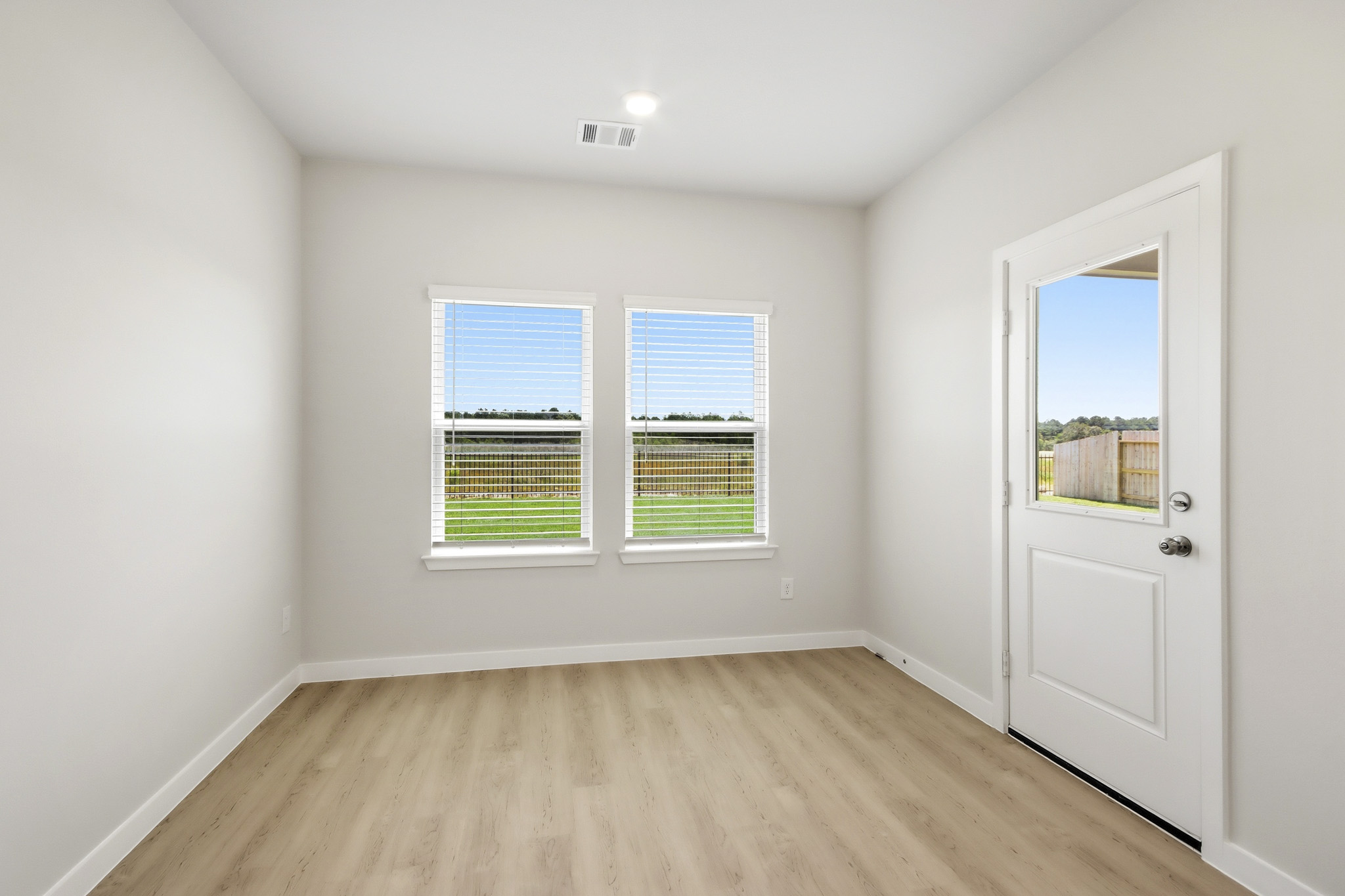 A room with a wood floor and a door with a window.
