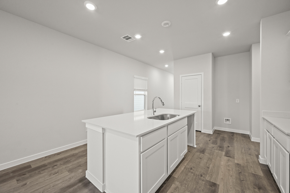 A kitchen with white cabinets.